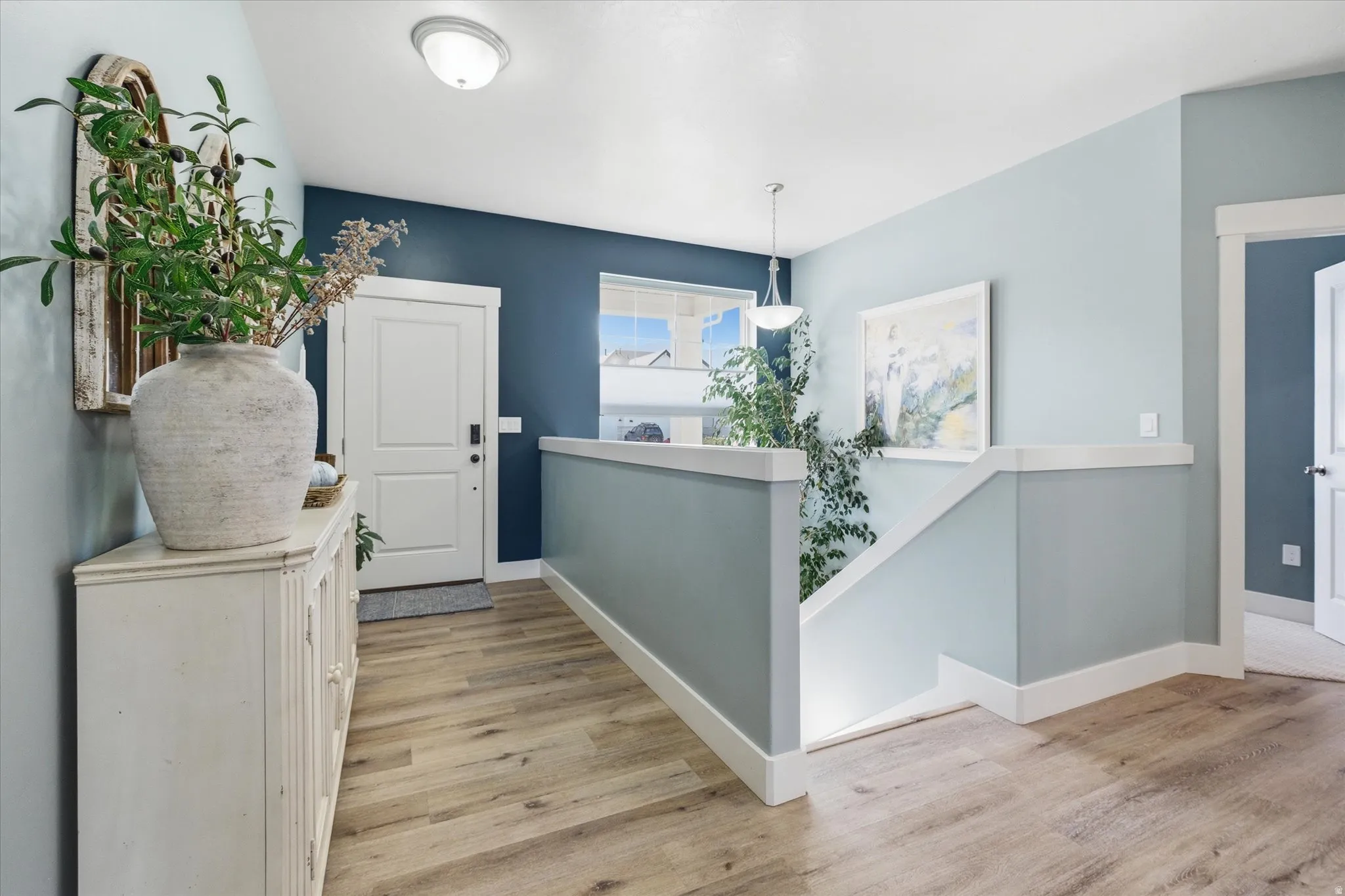 Light wood-finish flooring extending throughout the entry and hallway