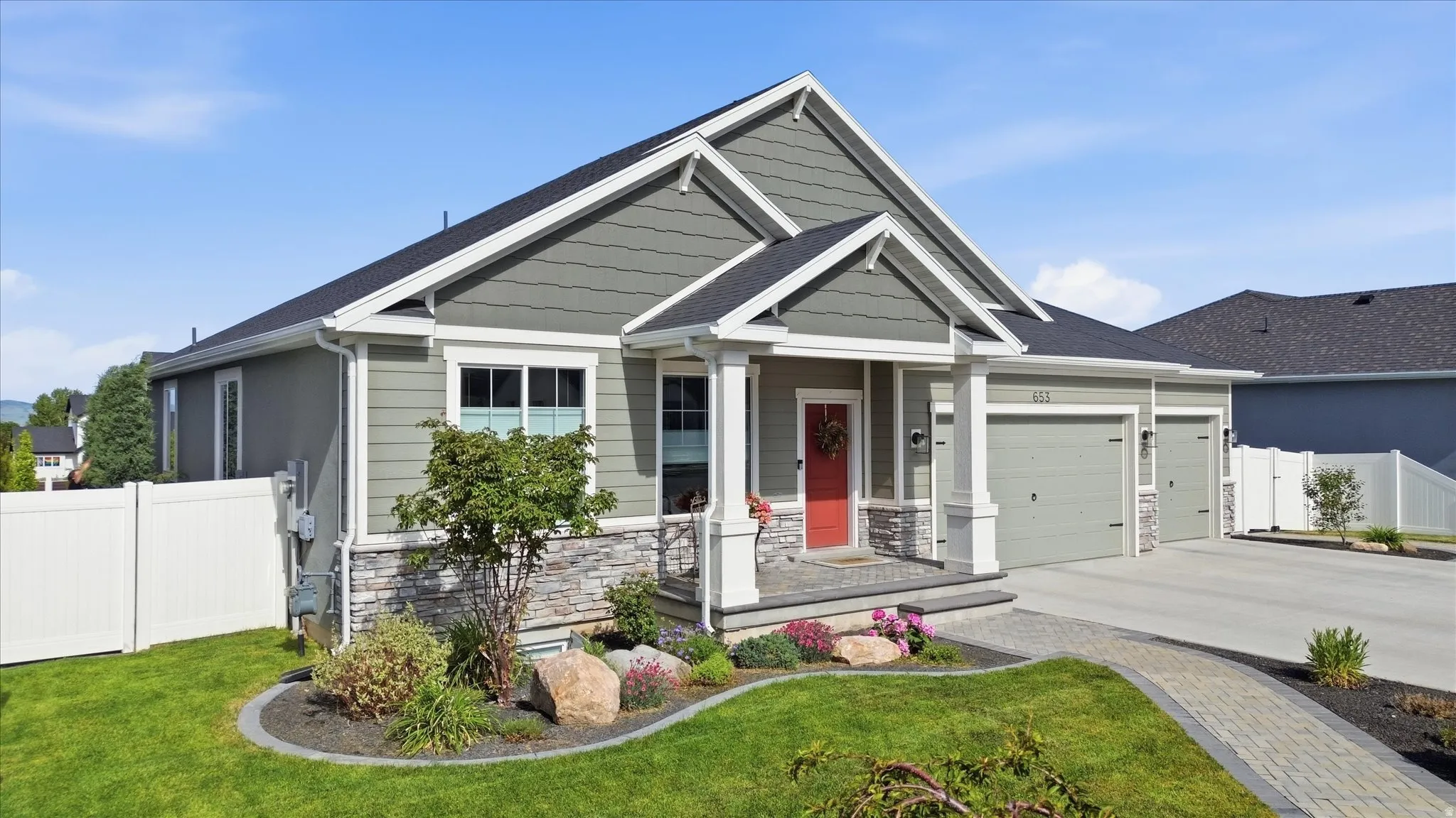 Single-story residence featuring a gray-green siding facade, white trim, and a prominent red entry door