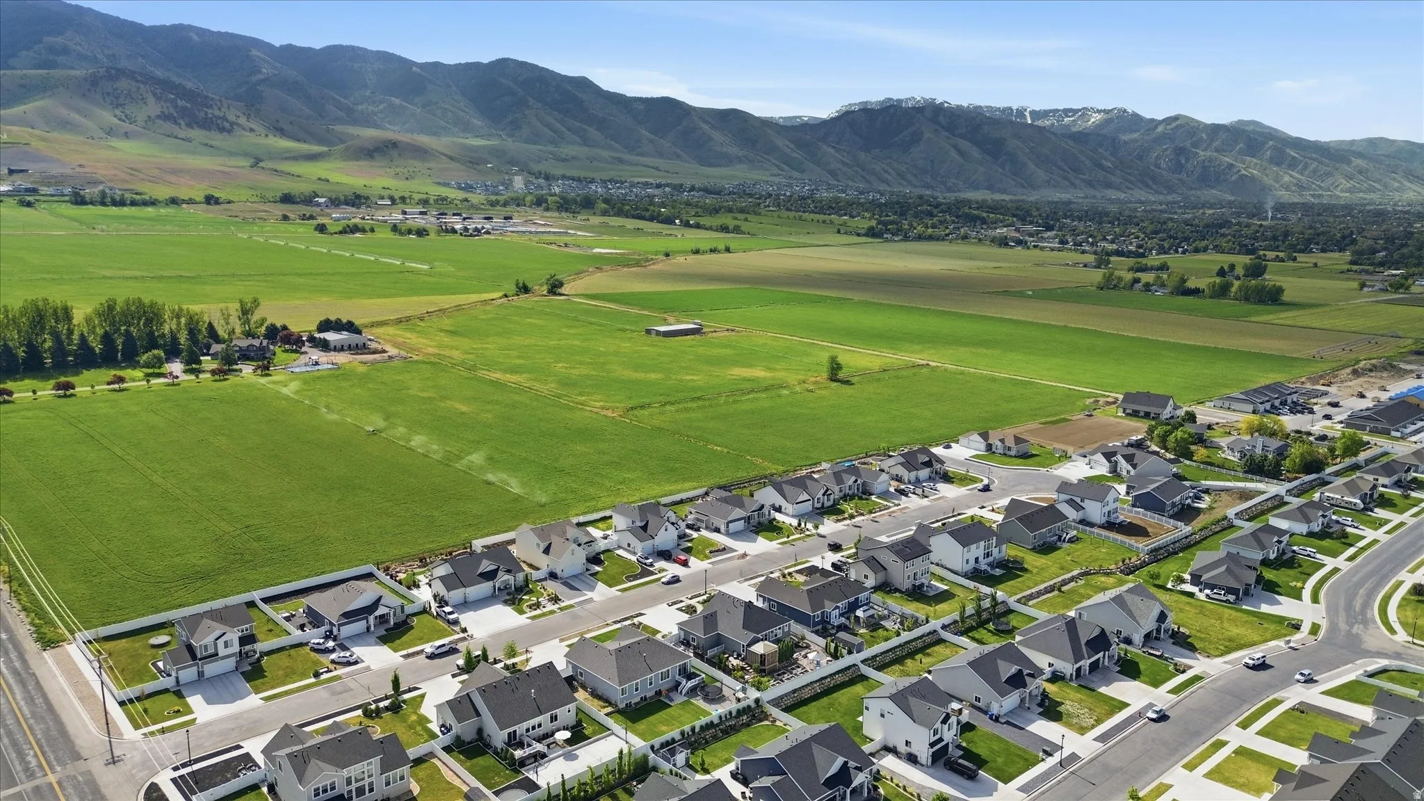 Newer residential community featuring contemporary-style homes with dark shingle roofs and light-colored exteriors