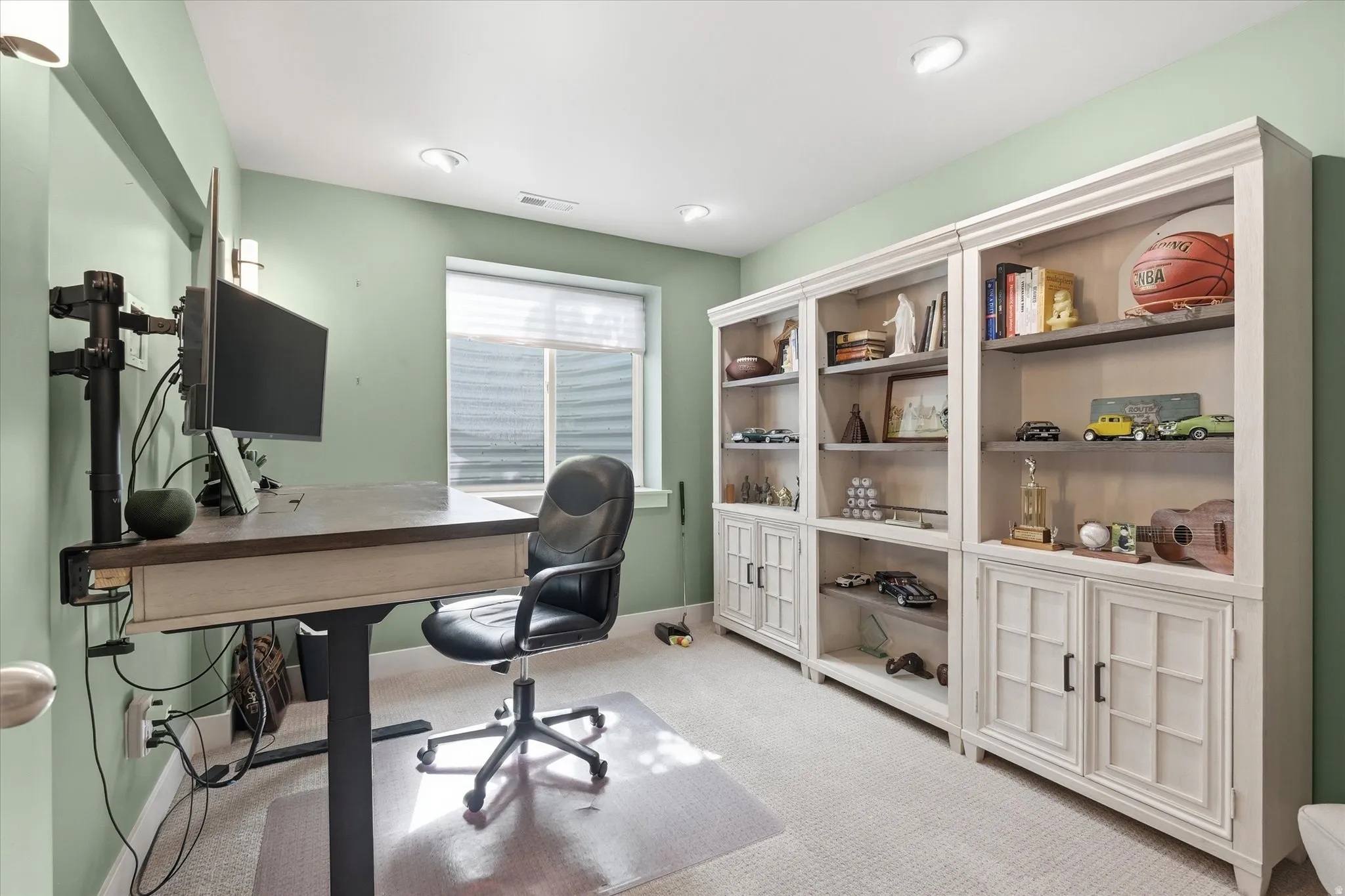 Spacious room with recessed lighting, light green walls, and carpeting