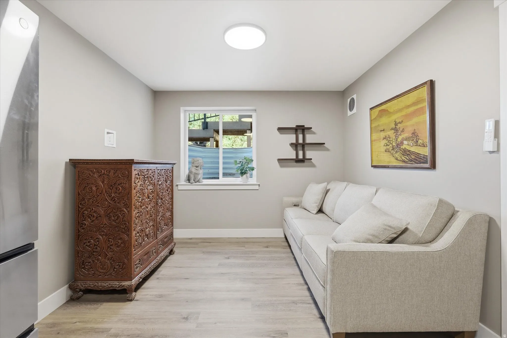 Apartment -Light gray walls define this interior space featuring wood-finish flooring