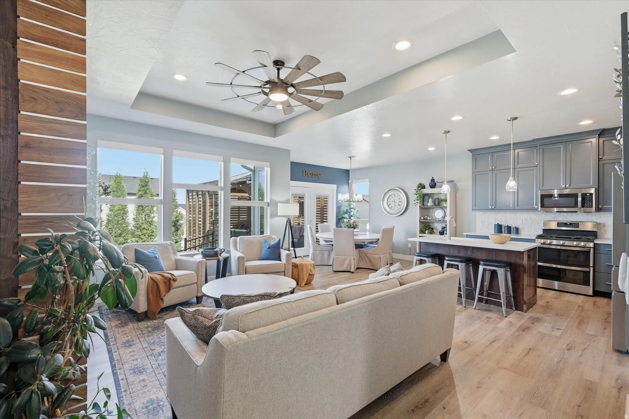 Open-concept living space featuring wood-finish flooring and expansive windows