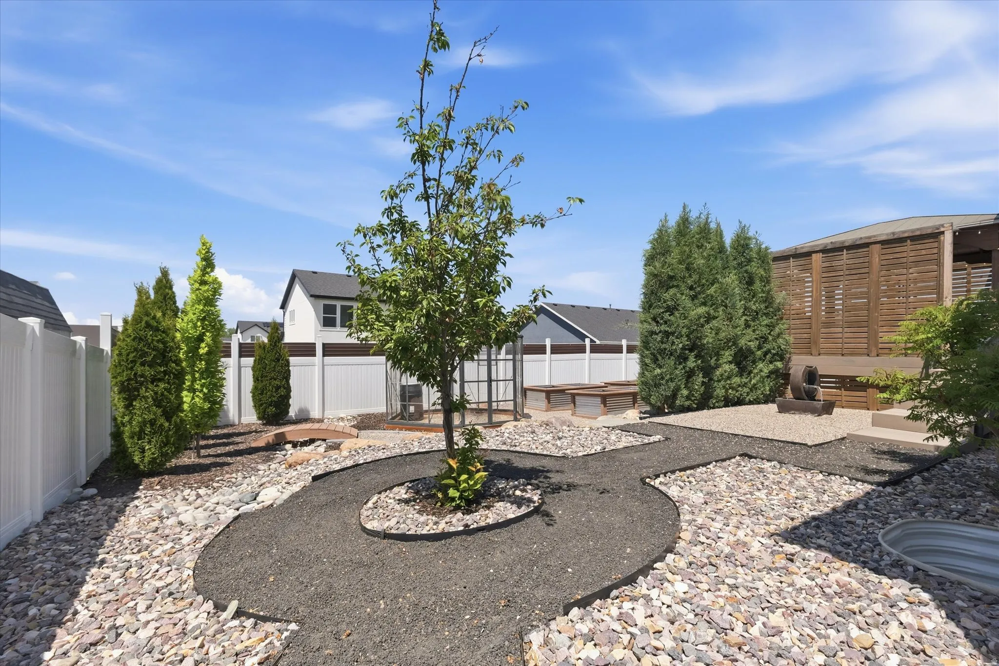 Landscaped backyard featuring decorative gravel and a walking path