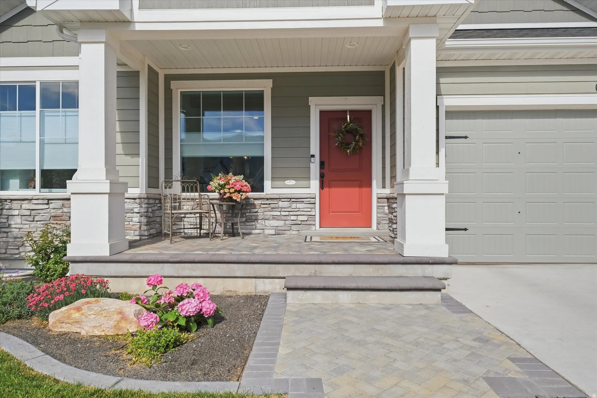 Front exterior featuring a prominent red entry door, white trim, and light green siding