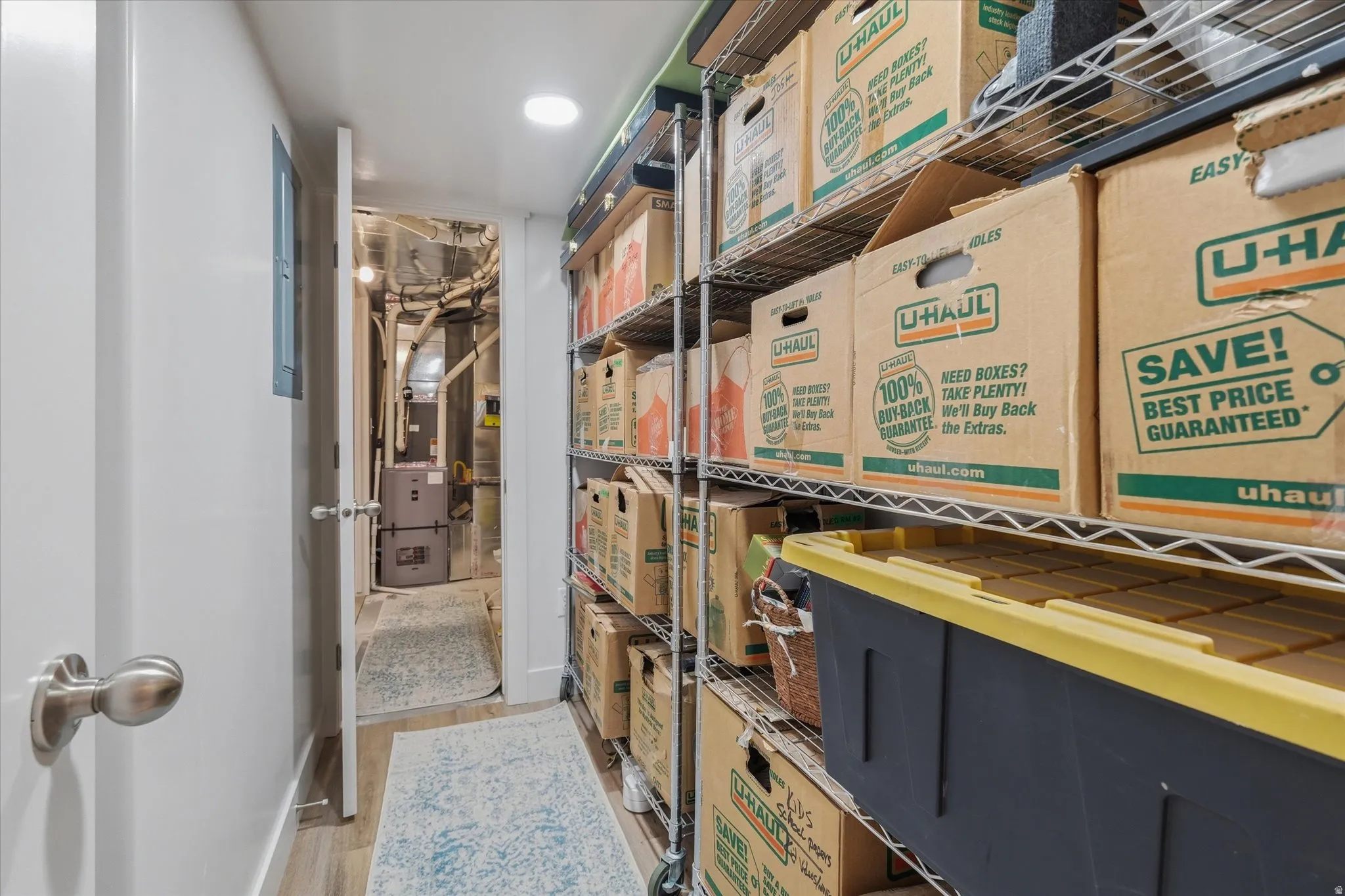 1 of 3 Dedicated utility spaces- featuring a furnace, water heater, and extensive metal shelving for organized storage