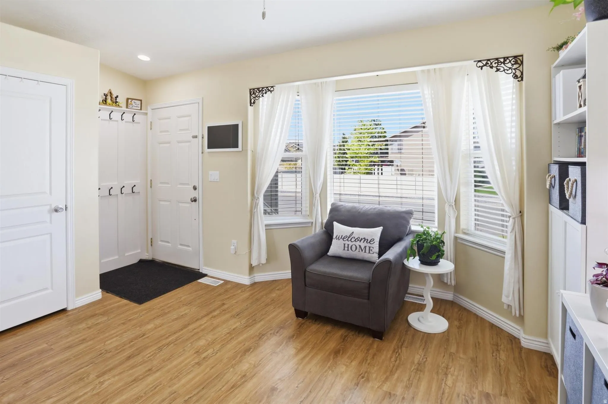 Entryway featuring wood-finish flooring, a front door, and a built-in closet with bifold doors