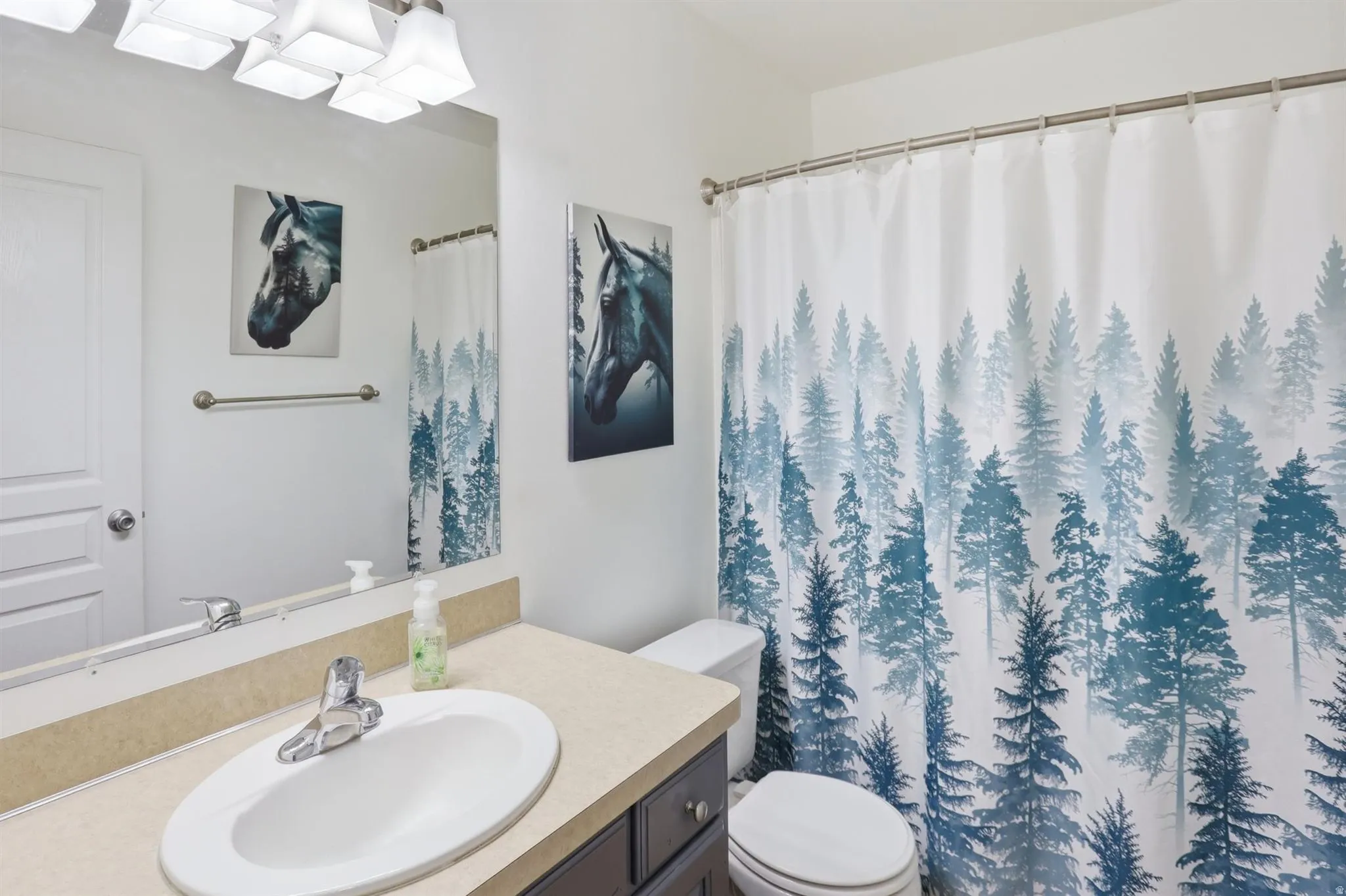 Main Bathroom featuring a light-colored countertop with an oval undermount sink and a dark-finish vanity cabinet