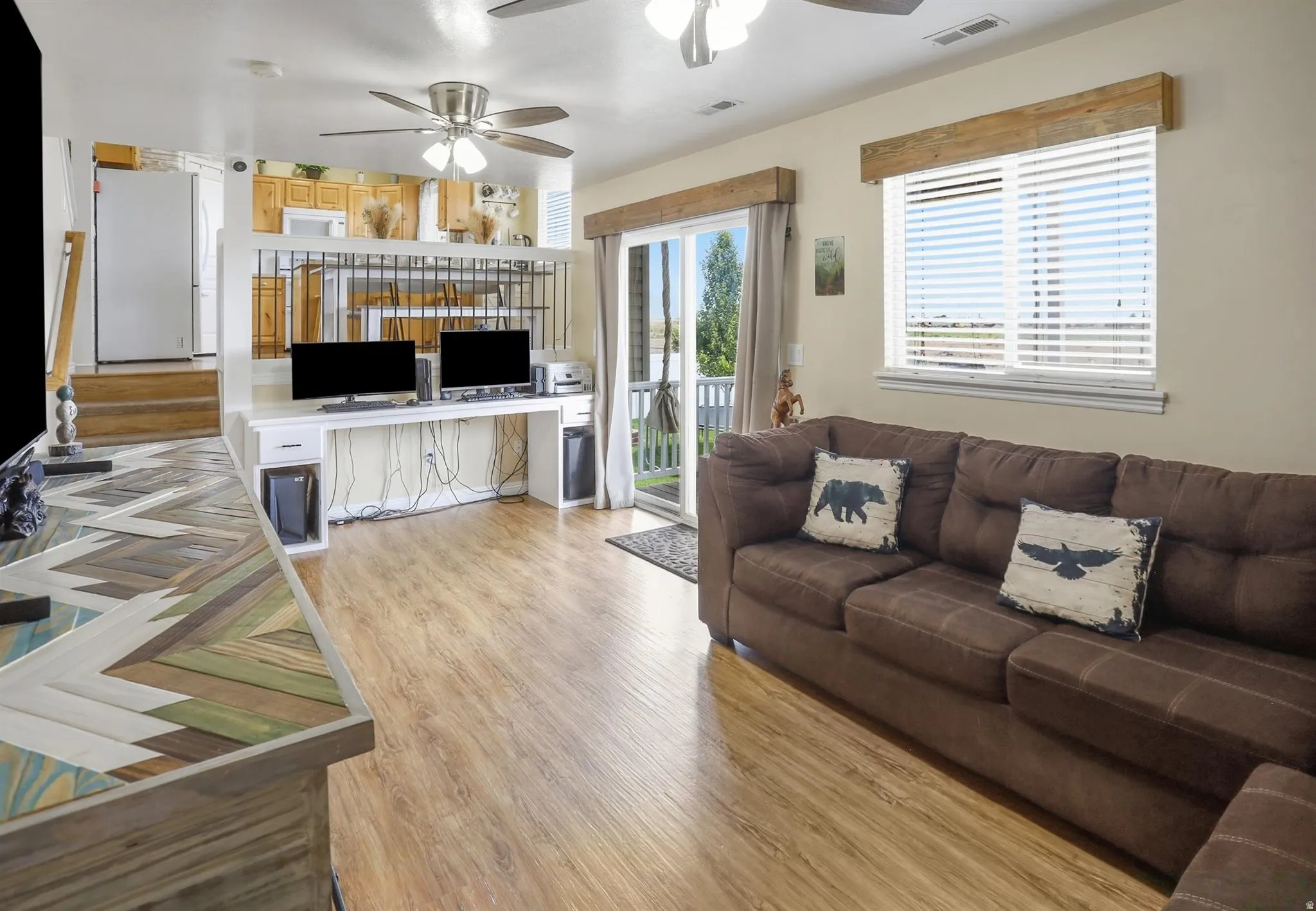 Open-concept living space featuring wood-finish flooring and neutral wall tones, walk out doors to covered deck