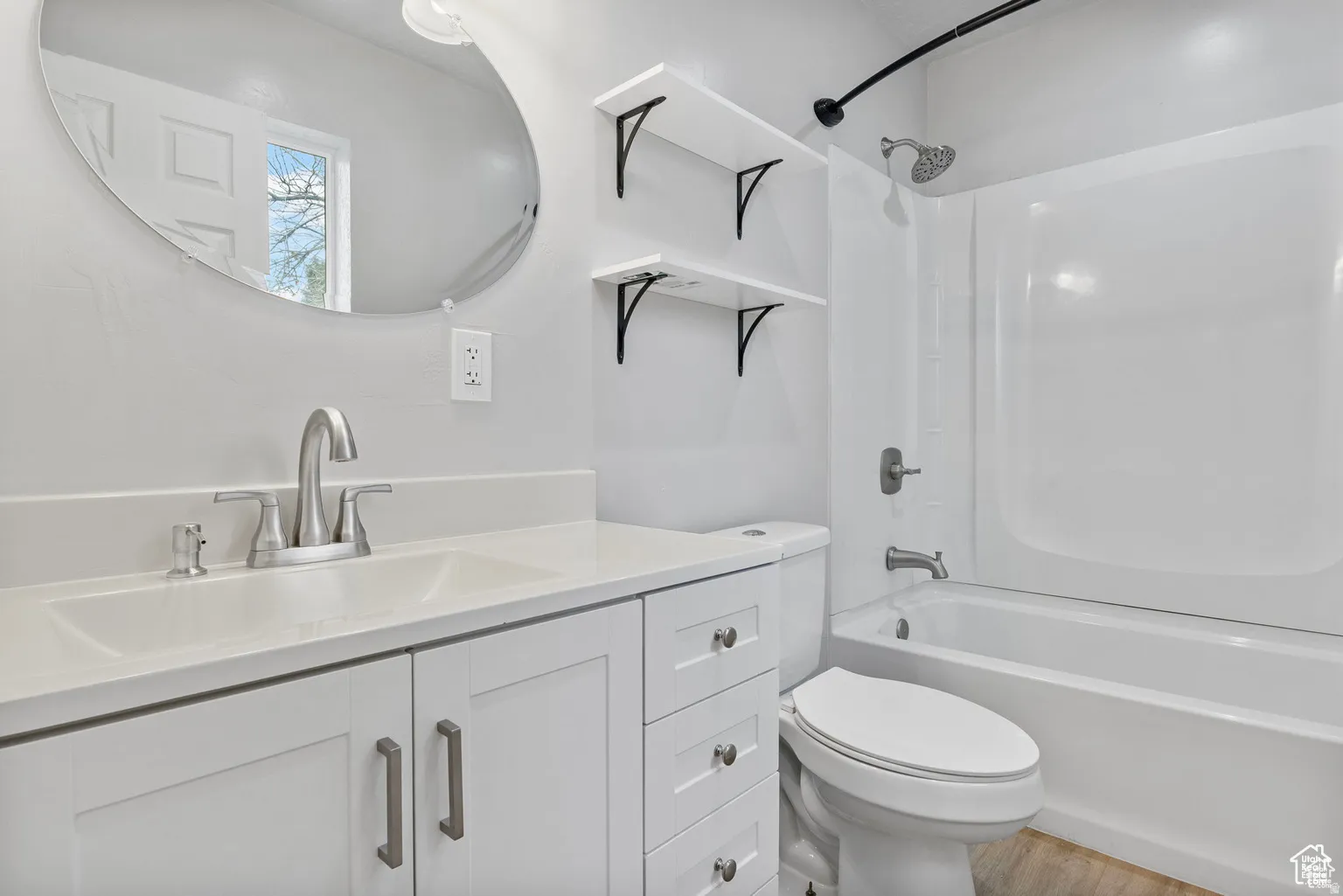Bathroom featuring a white vanity with integrated sink, brushed nickel faucet, and a quartz-finish countertop