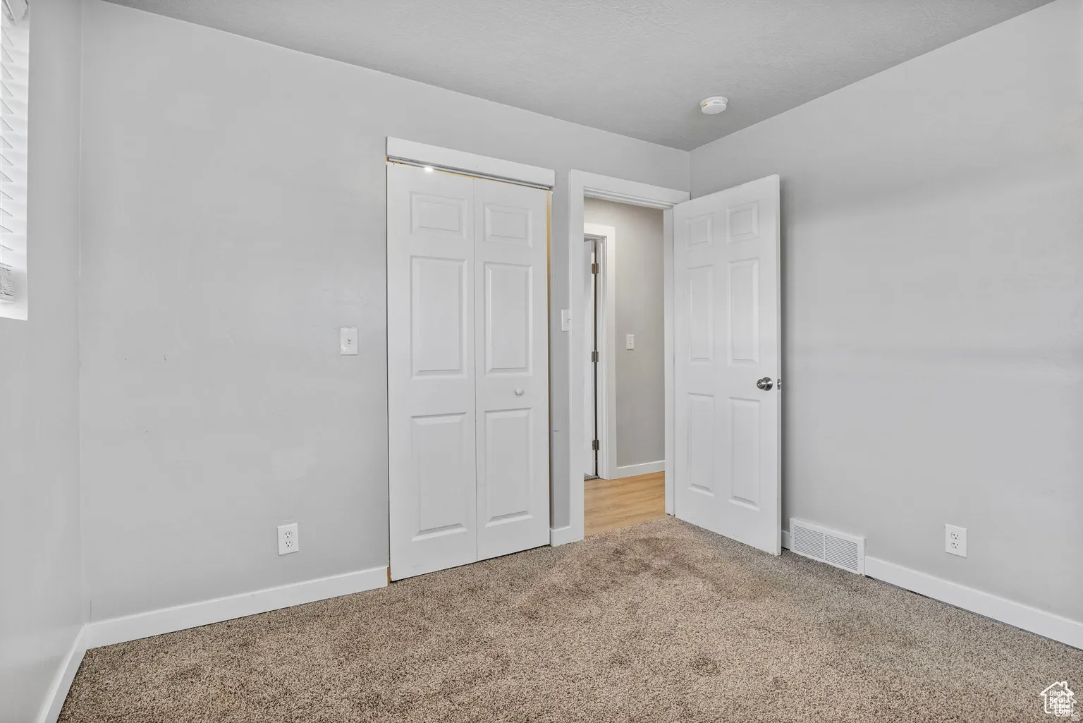 Room featuring light gray walls, white trim, and neutral carpet flooring