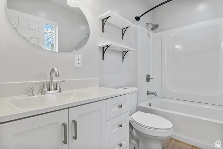 Bathroom featuring a white vanity with integrated sink, brushed nickel faucet, and a quartz-finish countertop