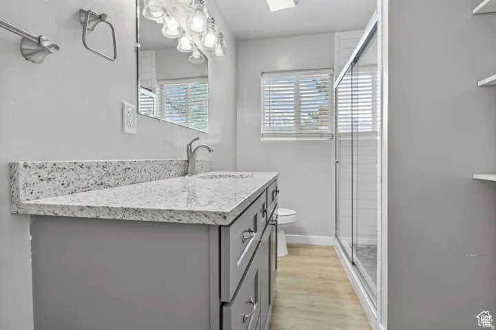 Bathroom vanity featuring a speckled countertop, undermount sink, and brushed nickel faucet