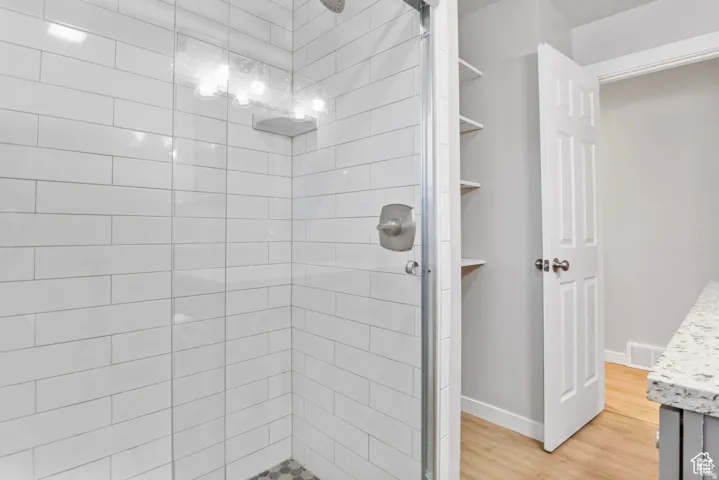 Walk-in shower with white subway tile surround, clear glass enclosure, and brushed nickel fixtures