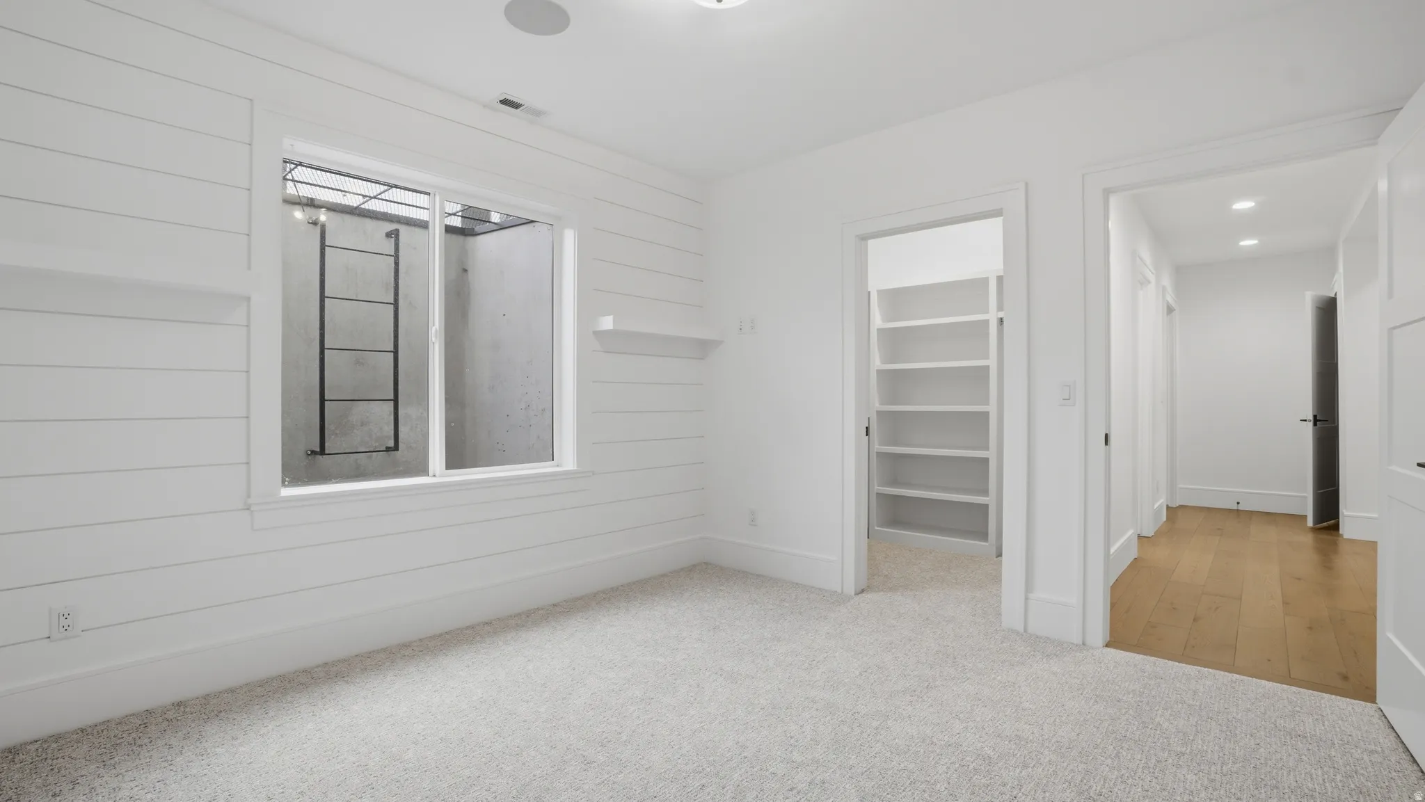 Room featuring light-colored carpeting and shiplap wall finishes