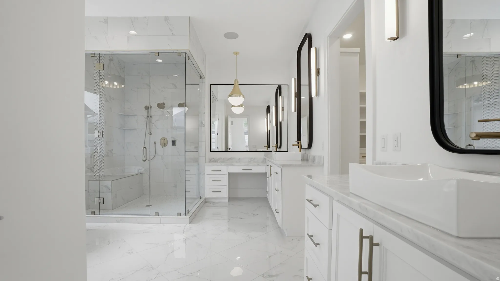Spacious bathroom featuring a frameless glass shower enclosure with bench seating, dual vanity with vessel sinks, white cabinetry, and large format tiled flooring