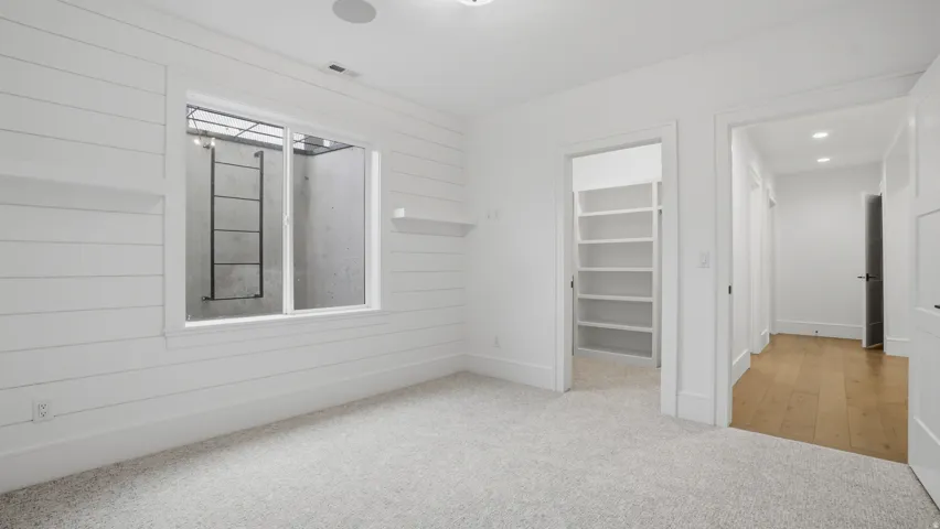Room featuring light-colored carpeting and shiplap wall finishes