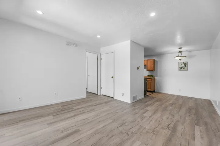 Open concept living area featuring wood-finish flooring and recessed lighting