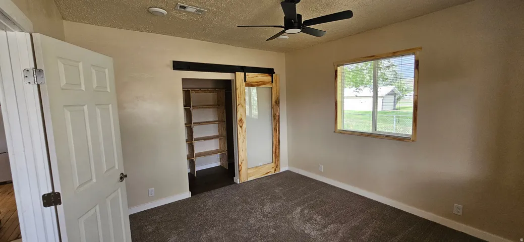 Interior room featuring textured walls and brown carpet flooring