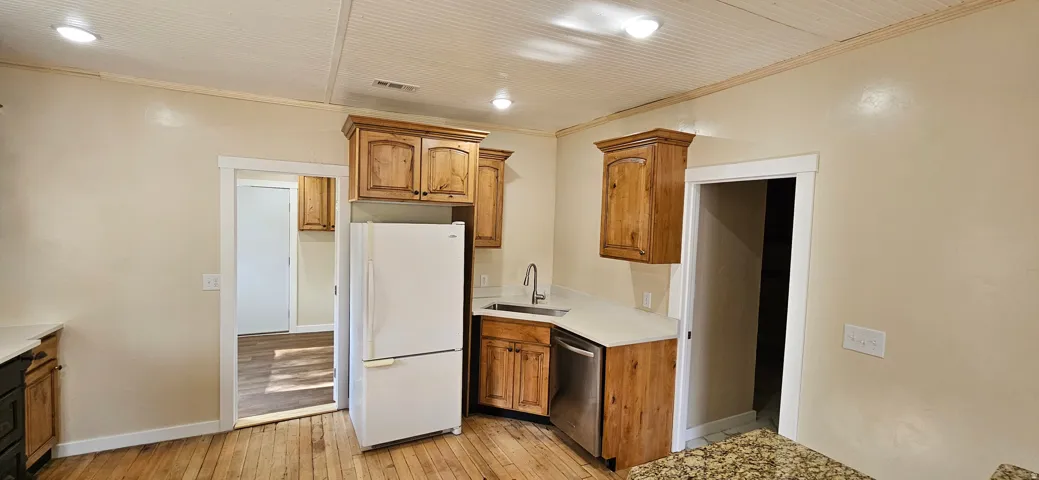Kitchen featuring wood cabinetry, light countertops, wood-finish flooring, recessed lighting, and a beadboard ceiling
