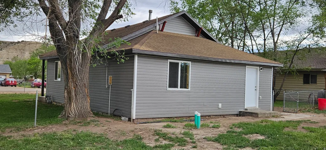 Exterior with gray horizontal siding and a brown shingle roof