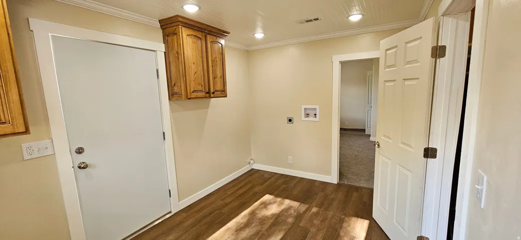 Utility space featuring wood-finish flooring, light-toned walls, and recessed lighting