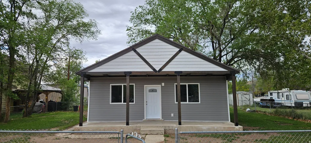 Single-story residence featuring gray horizontal siding and a contrasting white gable with brown trim