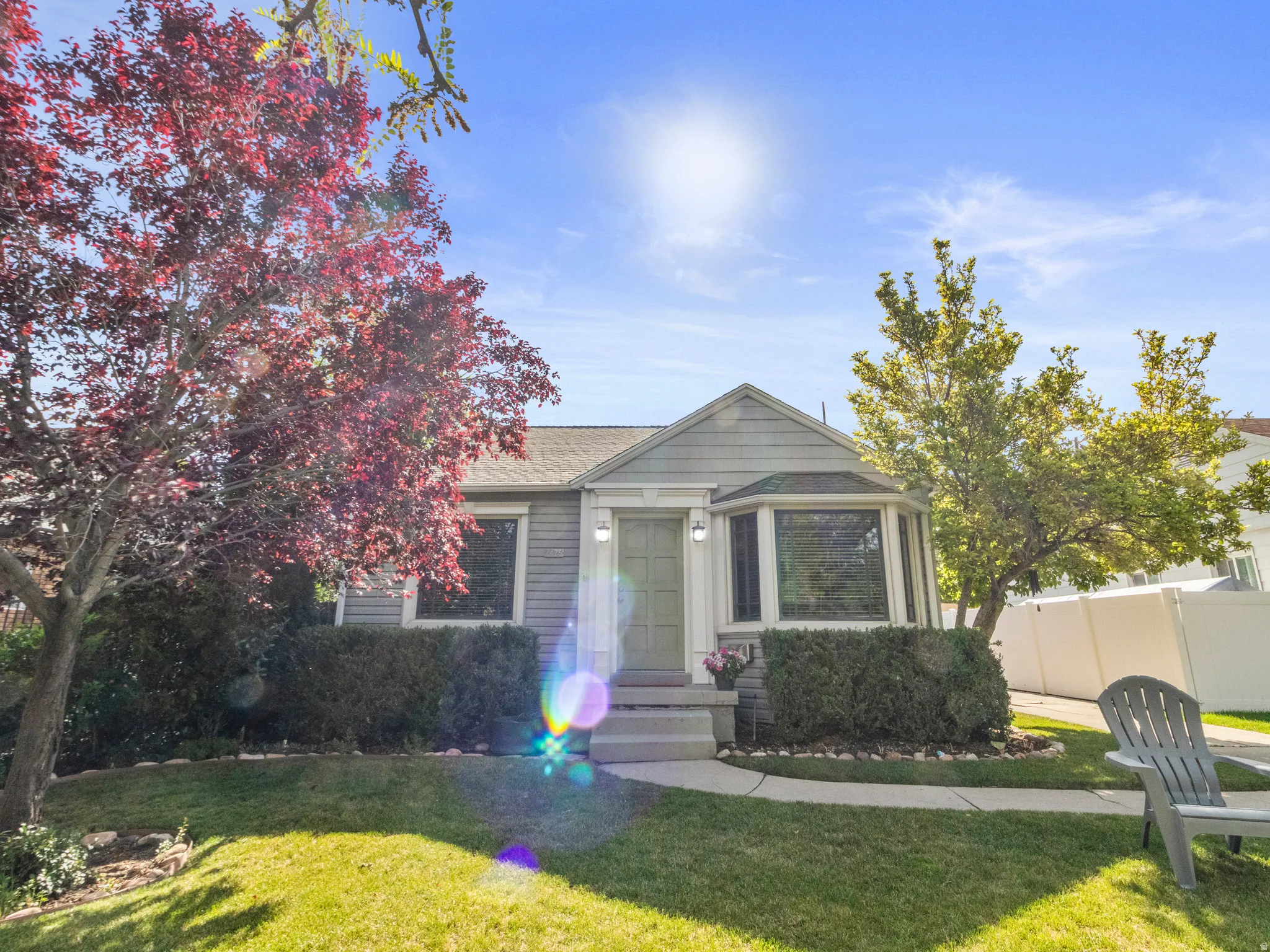Gray siding exterior with white trim, featuring a bay window and a covered front entry