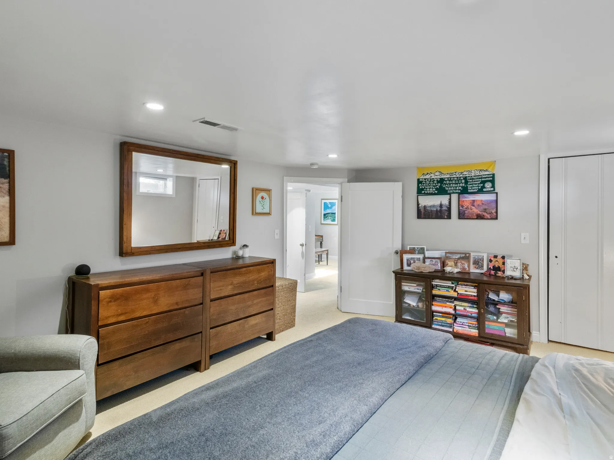 Recessed lighting illuminates this room featuring light-colored walls and carpeted flooring
