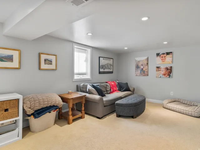 Finished room featuring recessed lighting, a window with blinds, light-toned carpeting, and light gray wall paint