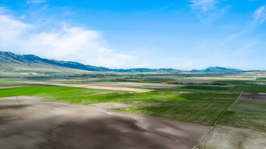 Expansive agricultural land featuring varied cultivated fields and distant mountain ranges