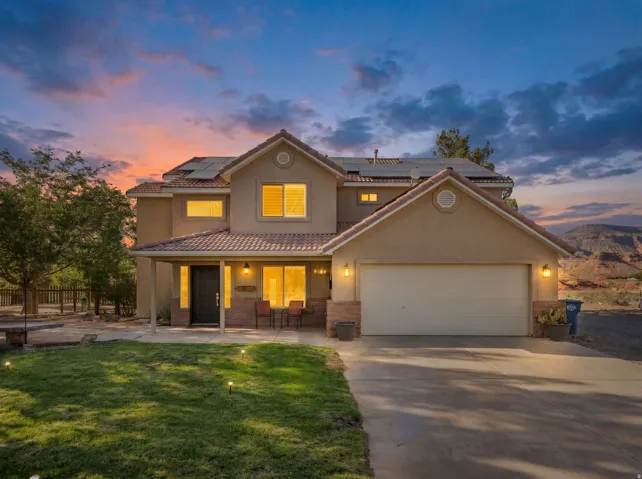 Two-story residence featuring a terracotta-style roof, stucco exterior, and an attached two-car garage
