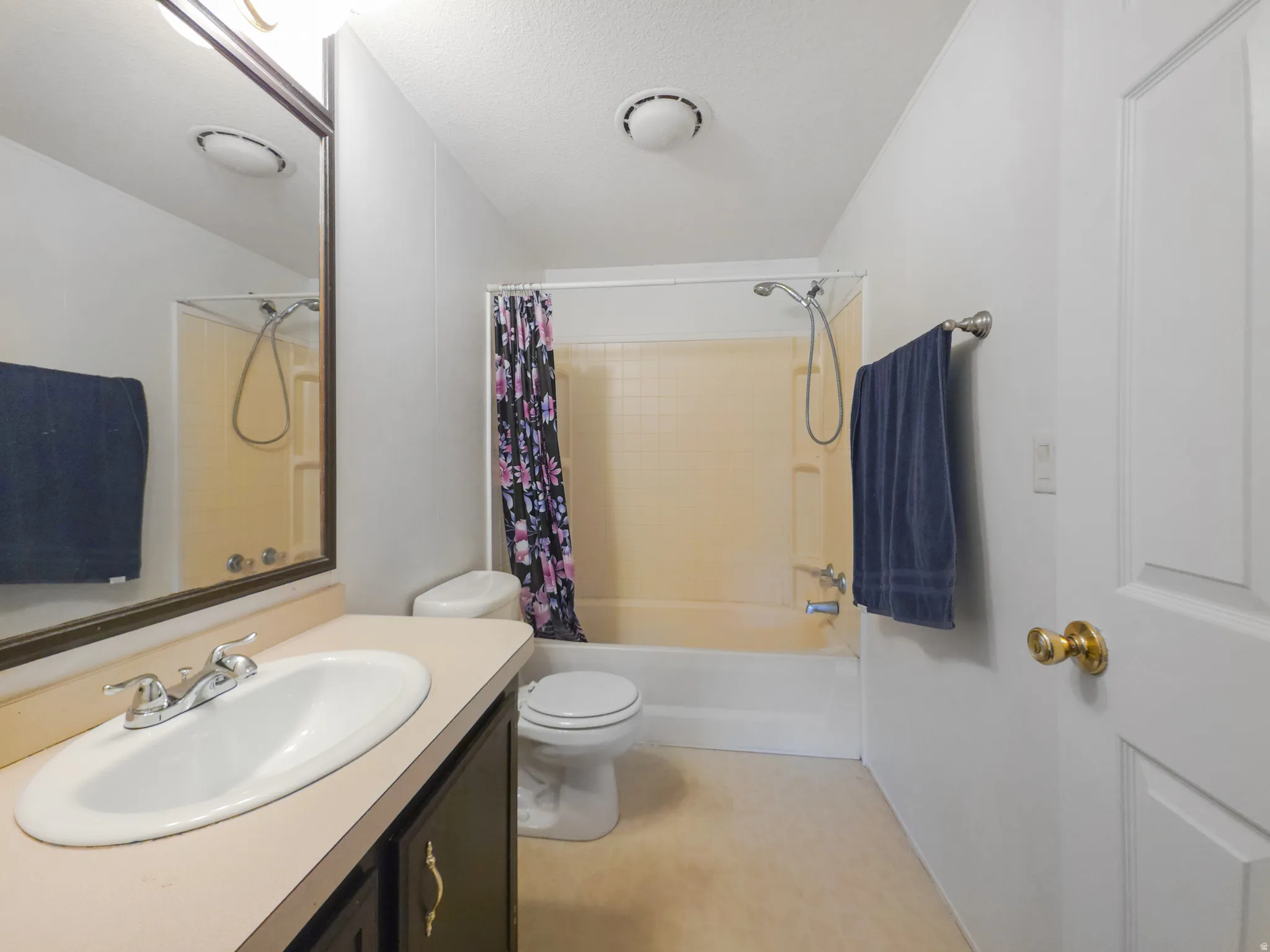 Full bathroom featuring a single vanity, a combination tub and shower, and neutral wall tones