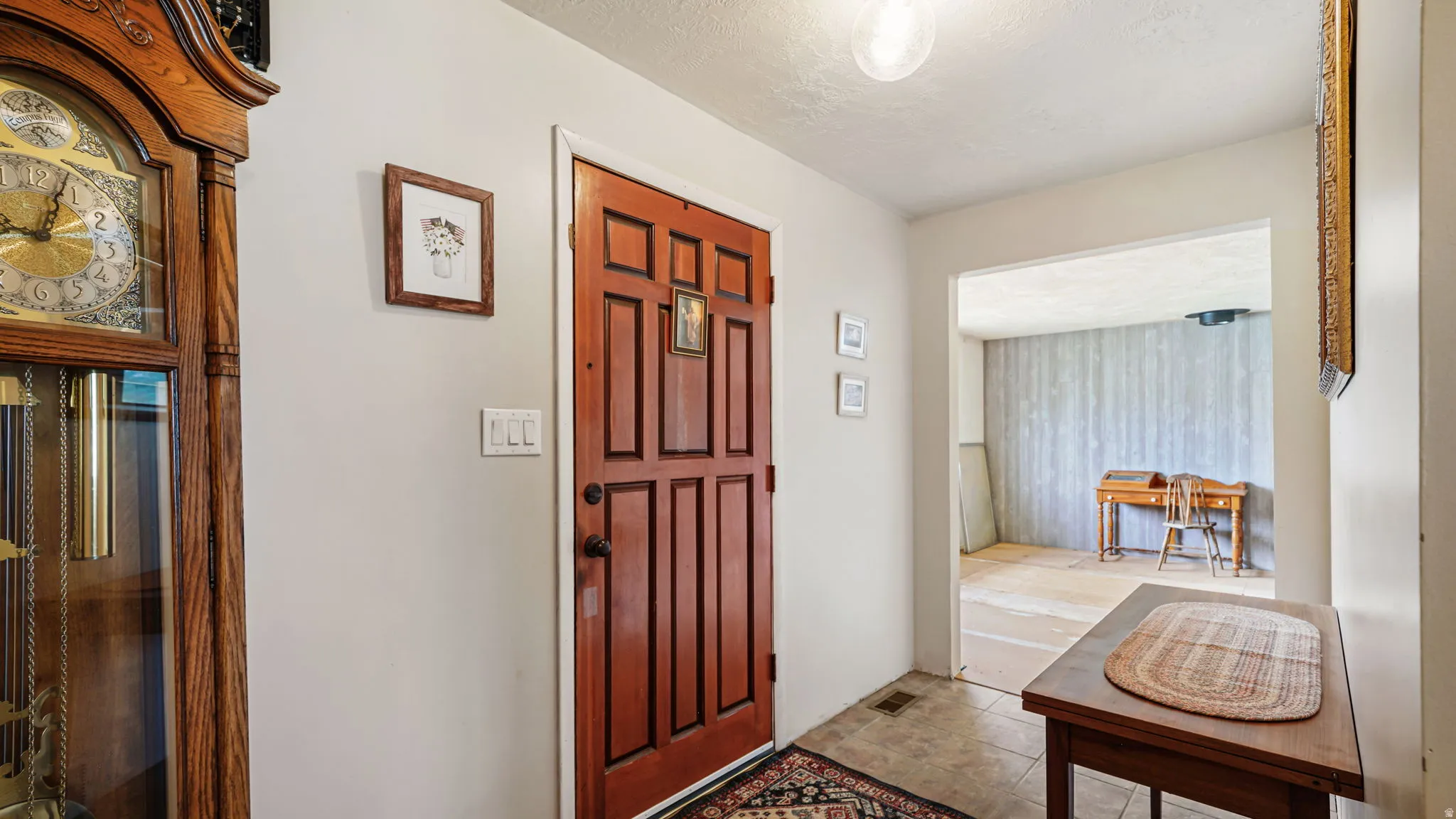 Entryway with a paneled wood-finish door, light-toned wall paint, and tile flooring