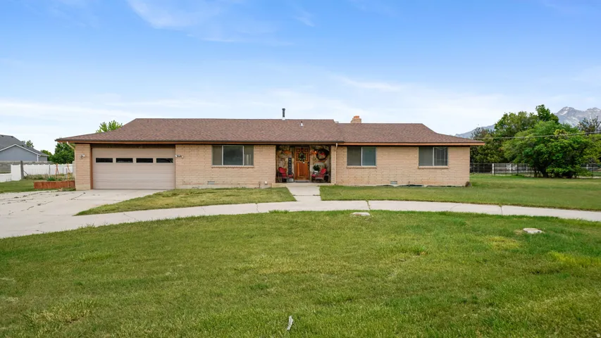 Ranch-style residence featuring a brick exterior and an attached garage with panel detailing