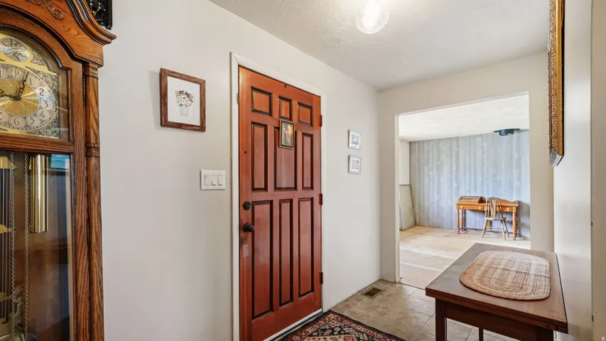 Entryway with a paneled wood-finish door, light-toned wall paint, and tile flooring