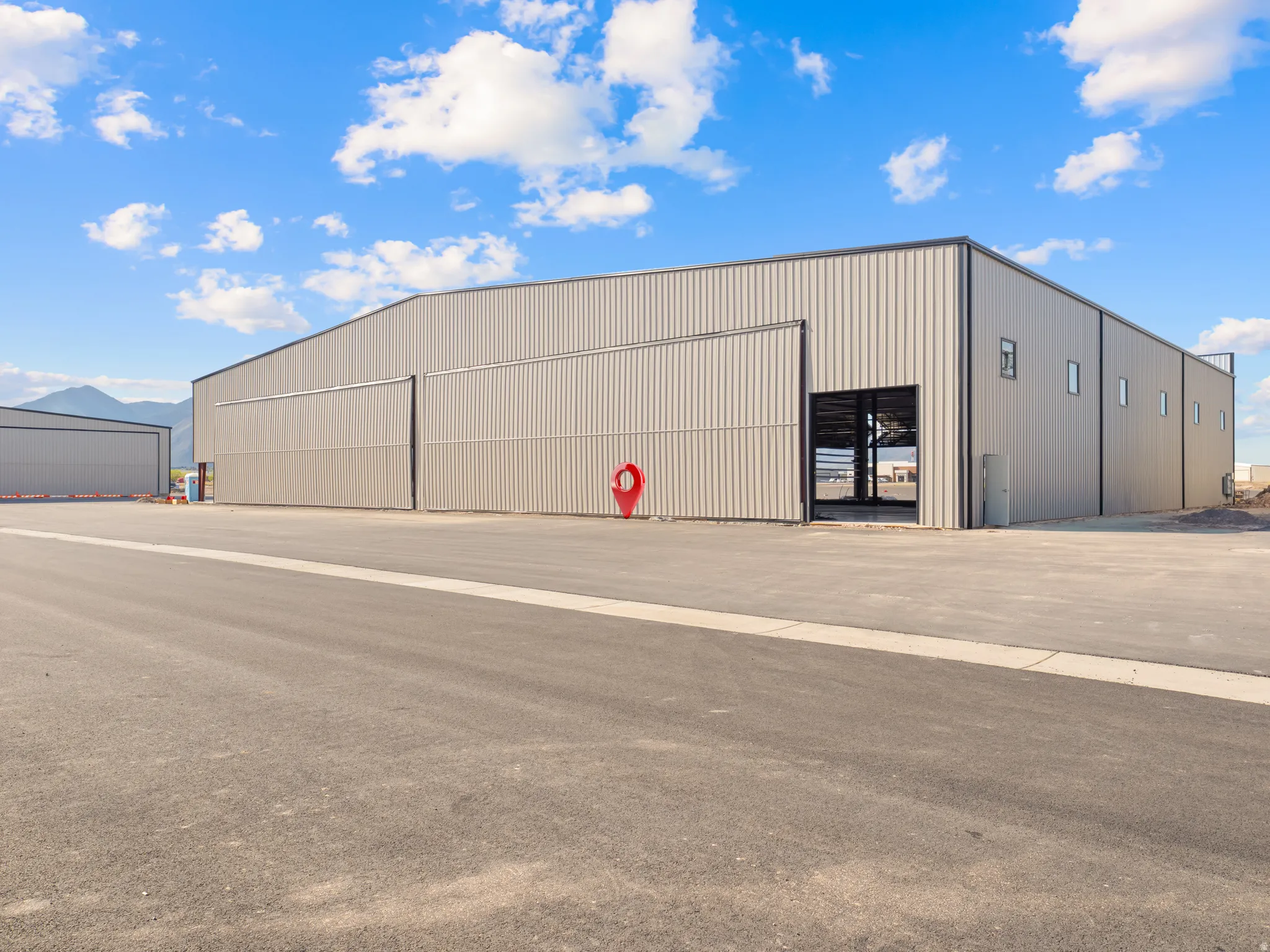 Industrial building featuring metal panel siding and a roll-up hangar door