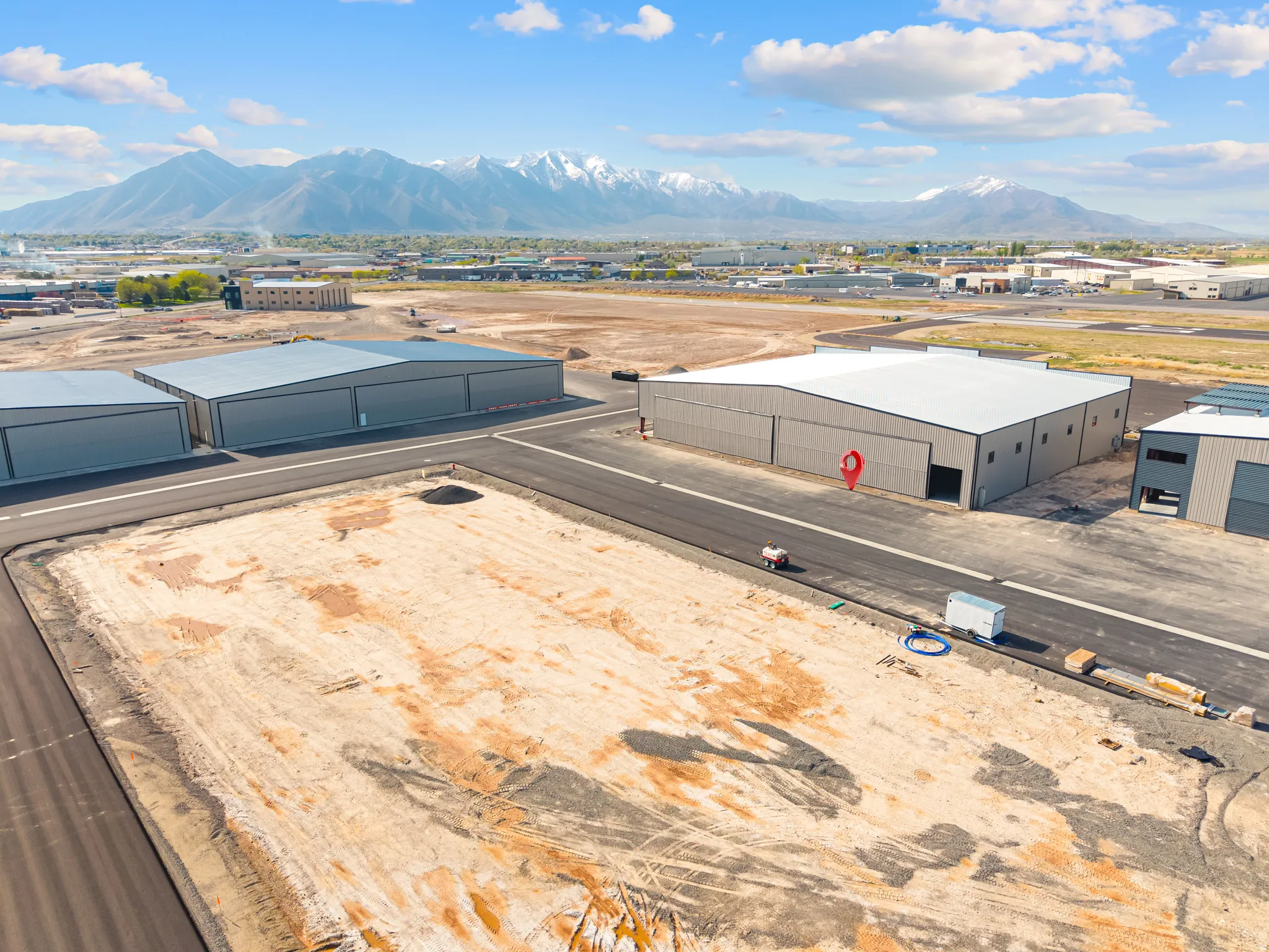 Newly developed commercial property featuring multiple metal hangar-style buildings with paved access ways