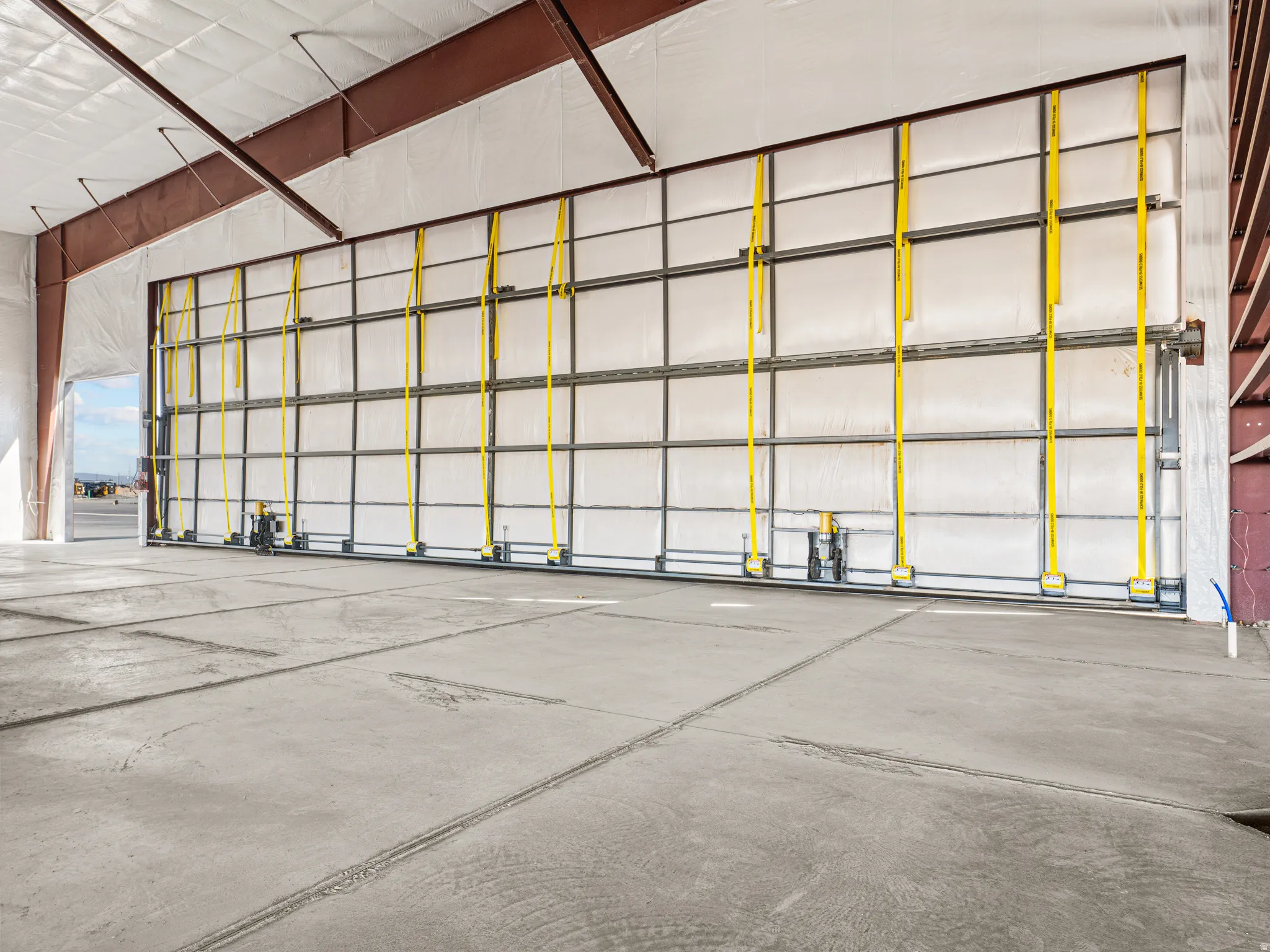Expansive concrete flooring in a large industrial space with metal beam construction