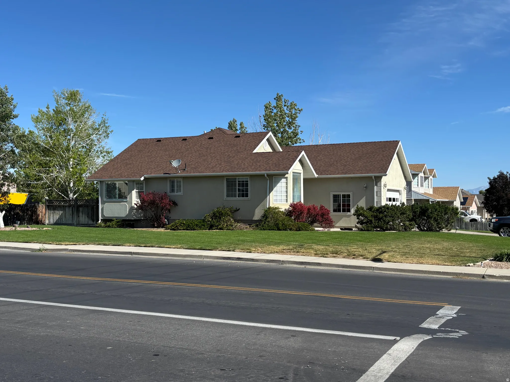 Ranch-style residence featuring a stucco exterior and a brown shingle roof