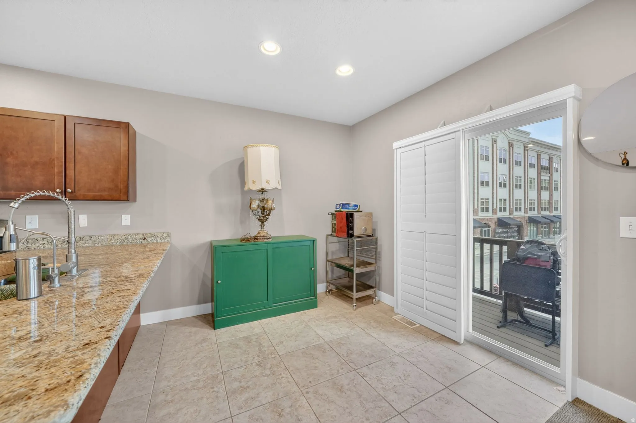 Kitchen area featuring warm wood cabinetry, a granite countertop, and a stainless steel gooseneck faucet