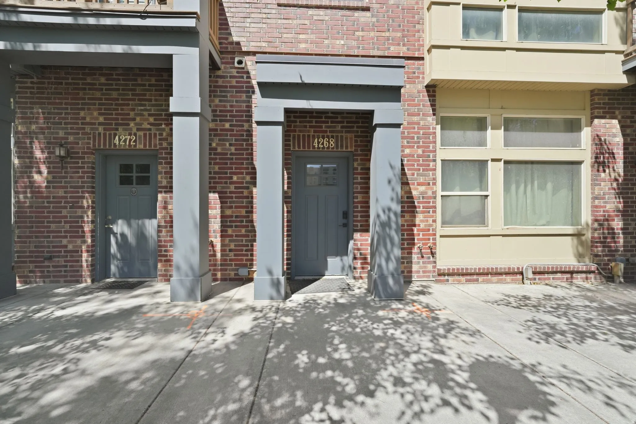 Brick facade with grey entry doors and covered porch entries