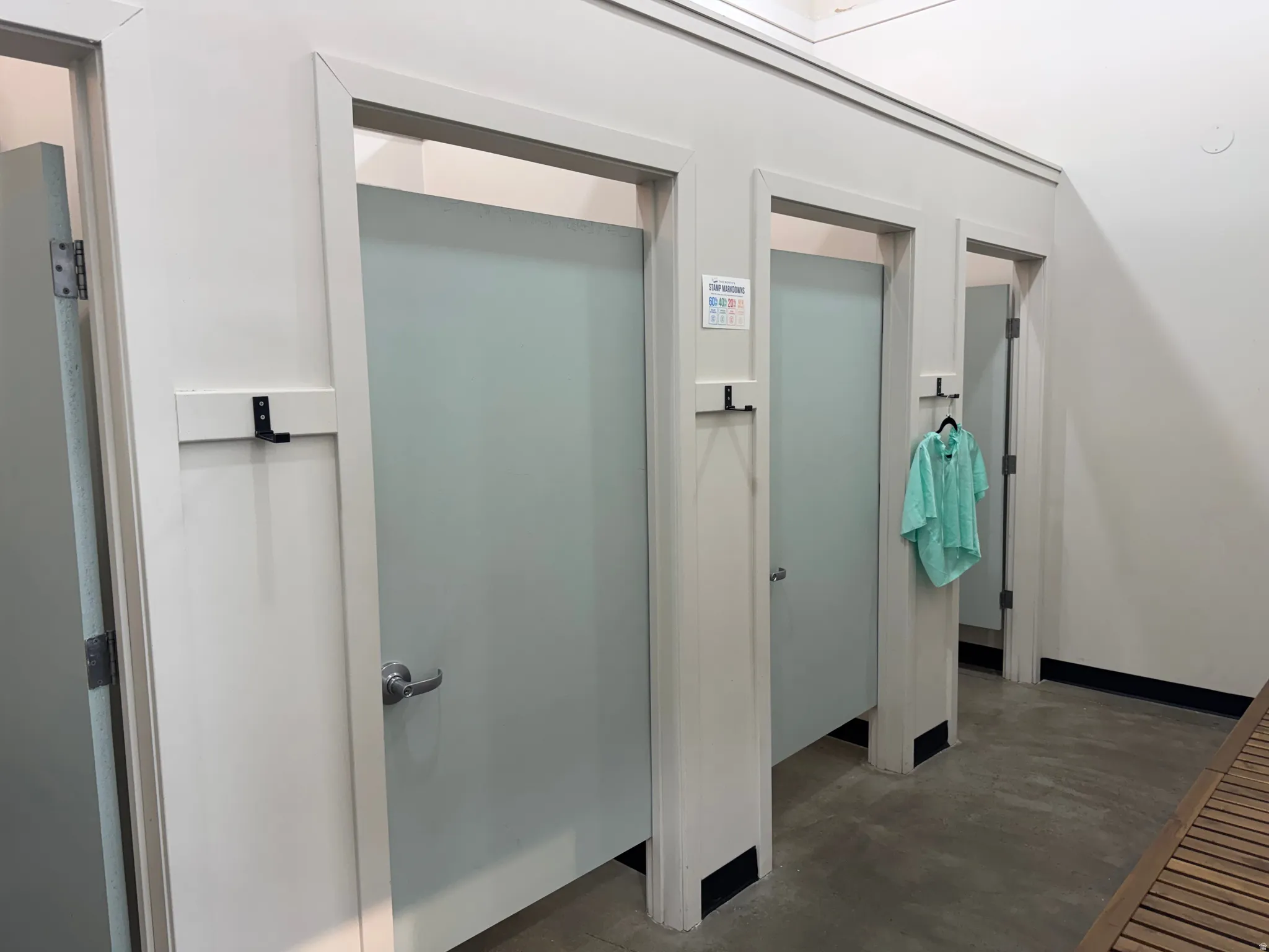 Three private stalls featuring frosted panels and individual coat hooks