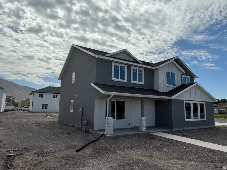 Contemporary home with a dark gray stucco exterior and white vertical siding accents