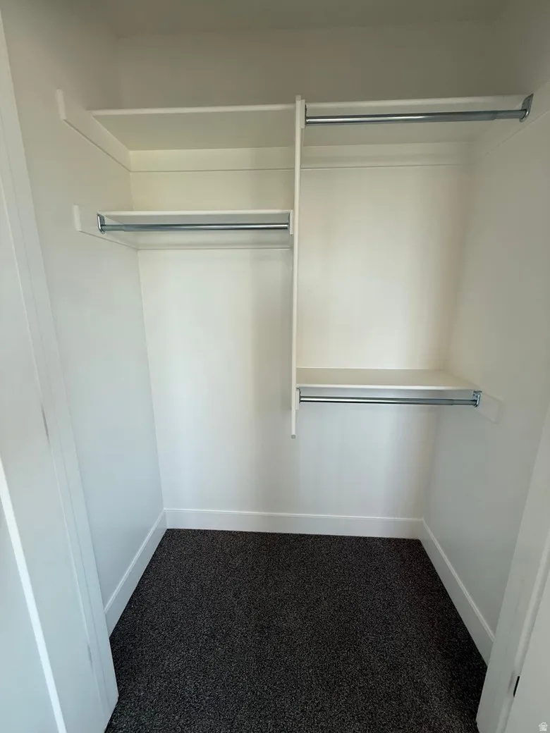 Interior closet featuring multiple white shelving units and chrome hanging rods