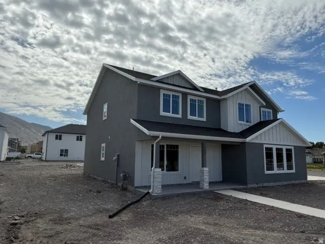Contemporary home with a dark gray stucco exterior and white vertical siding accents