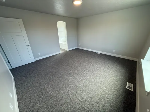 Spacious room featuring gray carpet flooring and light gray painted walls