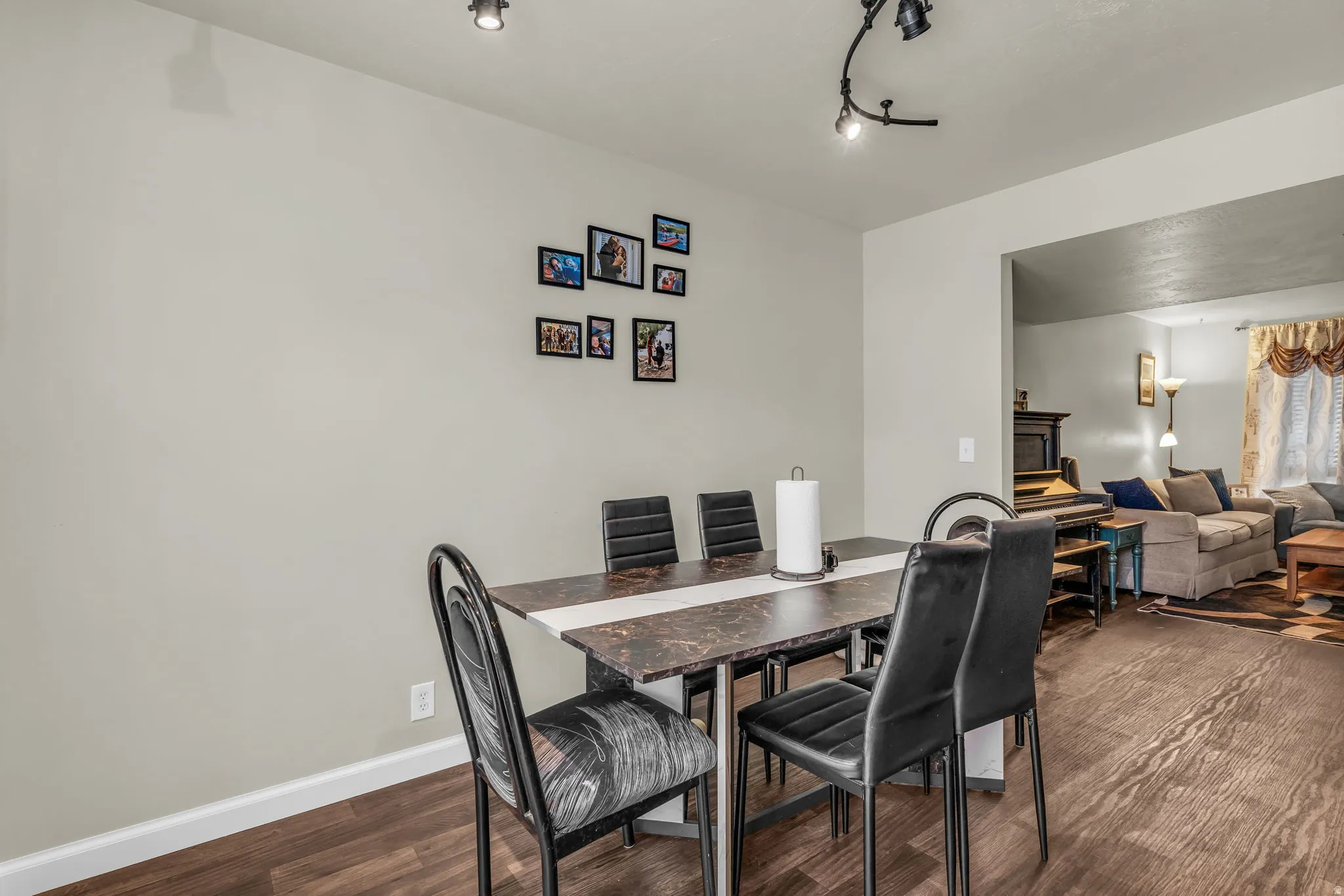 Dining area featuring wood-finish flooring, a neutral wall color, and track lighting