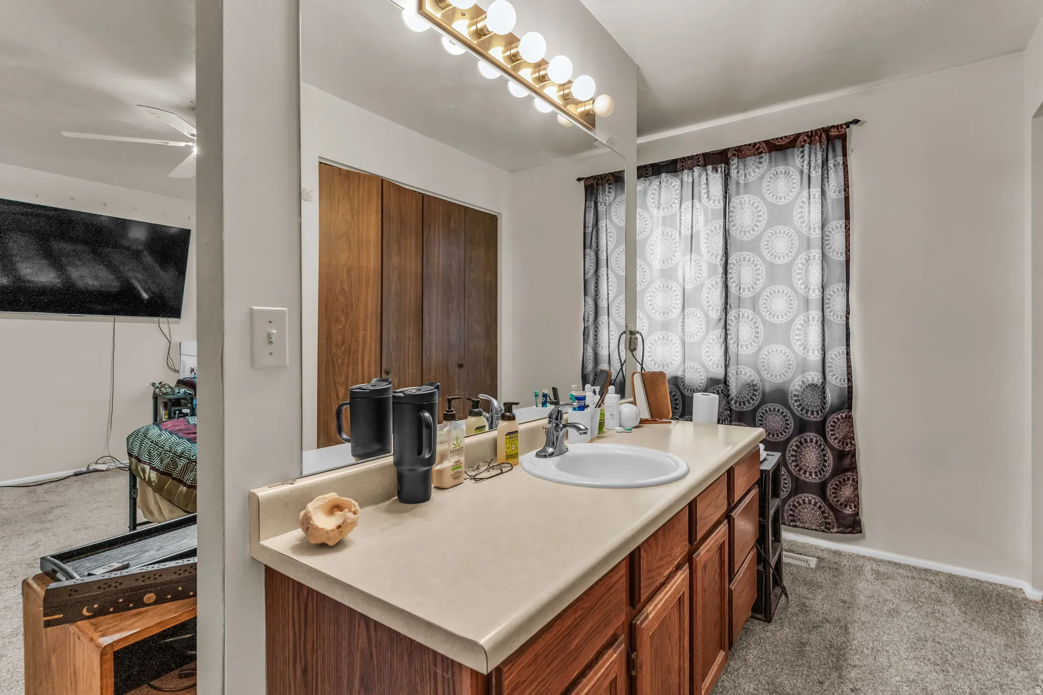 Bathroom vanity featuring an integrated sink, laminate countertop, and wood-finish cabinetry