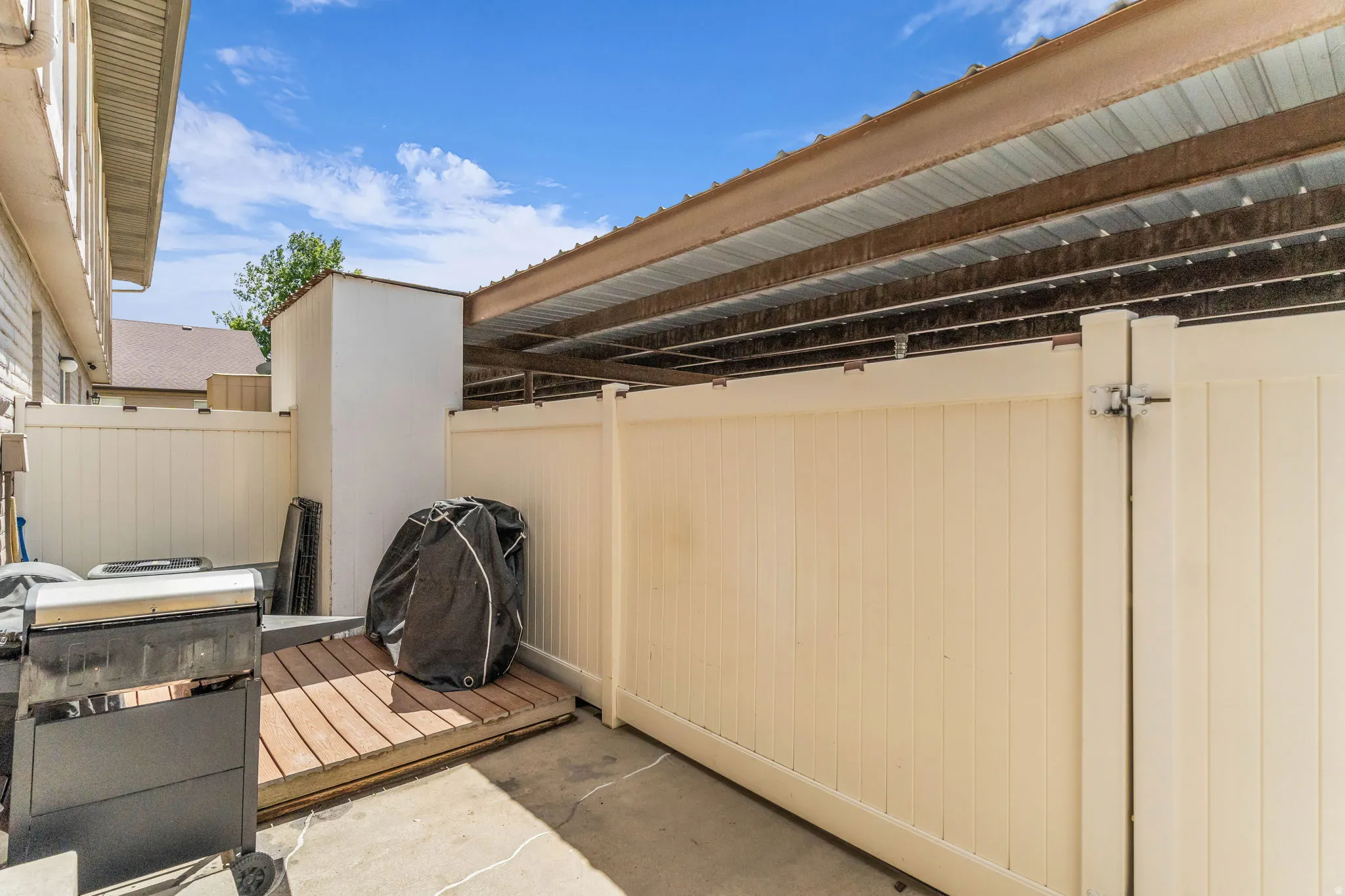 Paved patio area featuring privacy fencing and a dedicated wood-finish deck platform