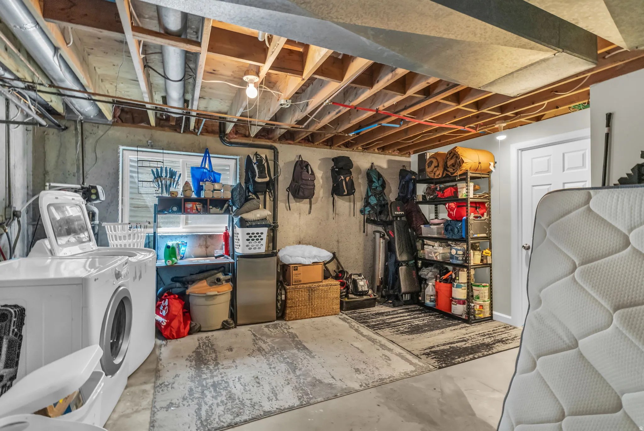 Utility area with concrete flooring and exposed ceiling joists